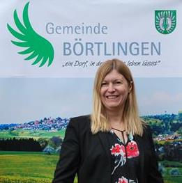 Bild der Bürgermeisterin Sabine Catenazzo vor dem Logo der Gemeinde Börtlingen